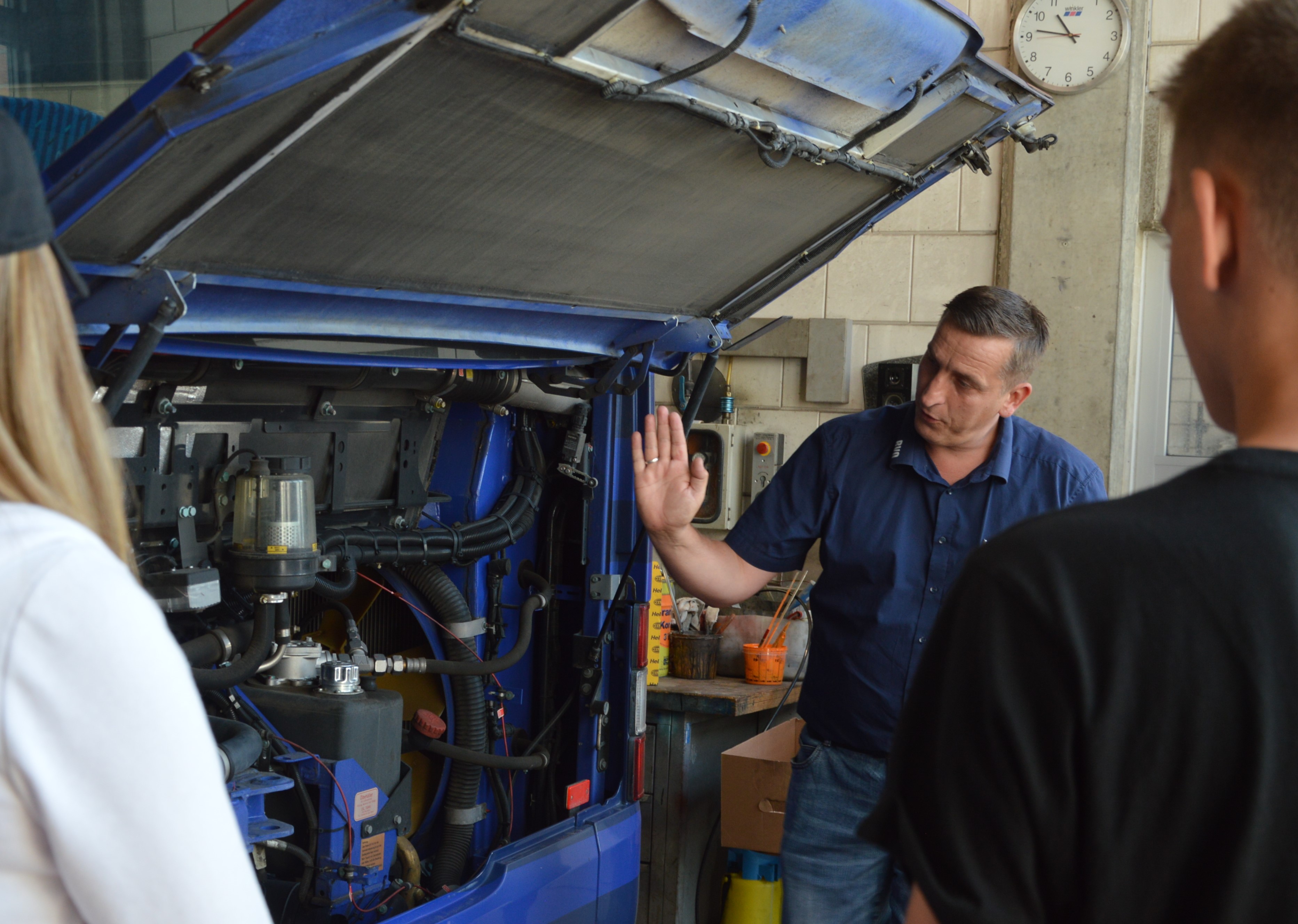 Werkstattleiter vor offenem Motor